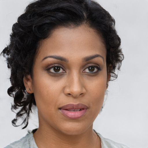 Joyful black young-adult female with long  brown hair and brown eyes