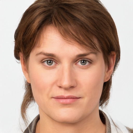 Joyful white young-adult female with medium  brown hair and grey eyes