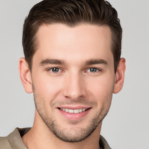 Joyful white young-adult male with short  brown hair and grey eyes