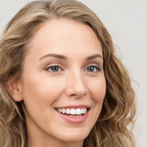 Joyful white young-adult female with long  brown hair and blue eyes