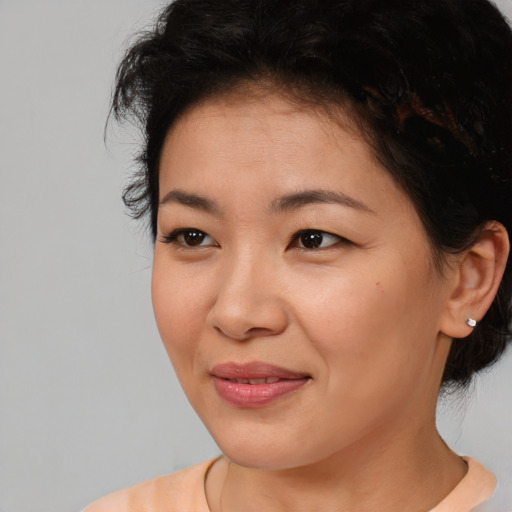 Joyful asian young-adult female with short  brown hair and brown eyes