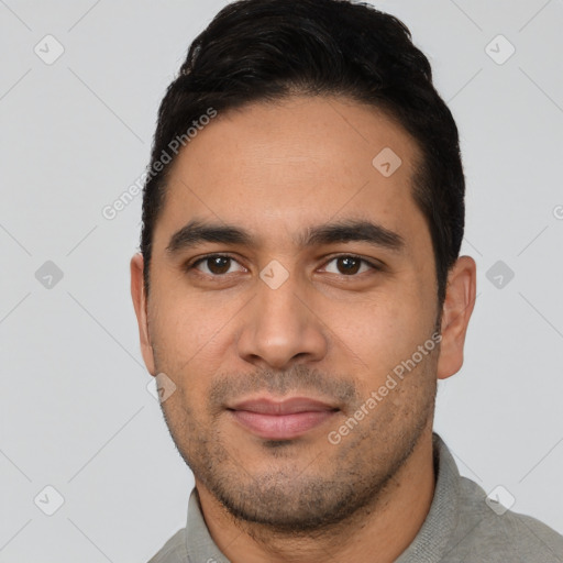 Joyful latino young-adult male with short  black hair and brown eyes