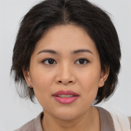 Joyful asian young-adult female with medium  brown hair and brown eyes