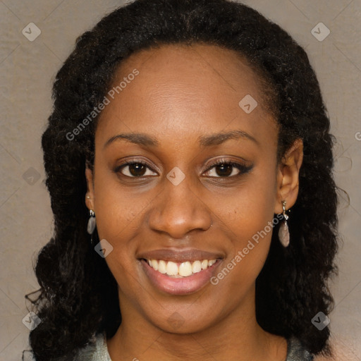 Joyful black young-adult female with long  black hair and brown eyes