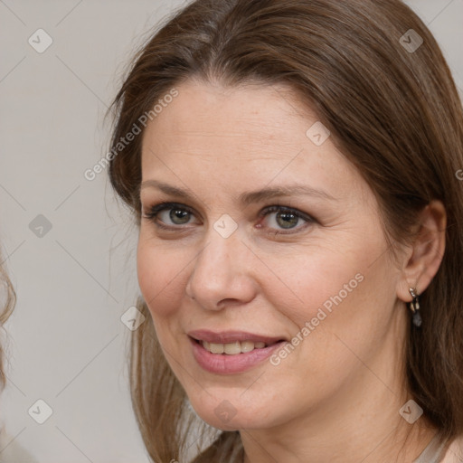 Joyful white adult female with medium  brown hair and grey eyes