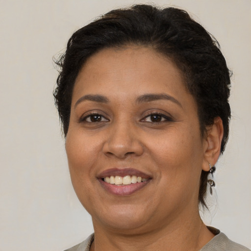 Joyful latino adult female with short  brown hair and brown eyes
