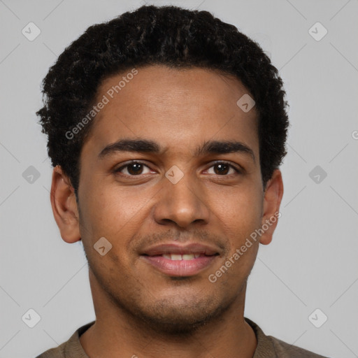 Joyful black young-adult male with short  brown hair and brown eyes