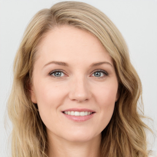 Joyful white young-adult female with long  brown hair and blue eyes