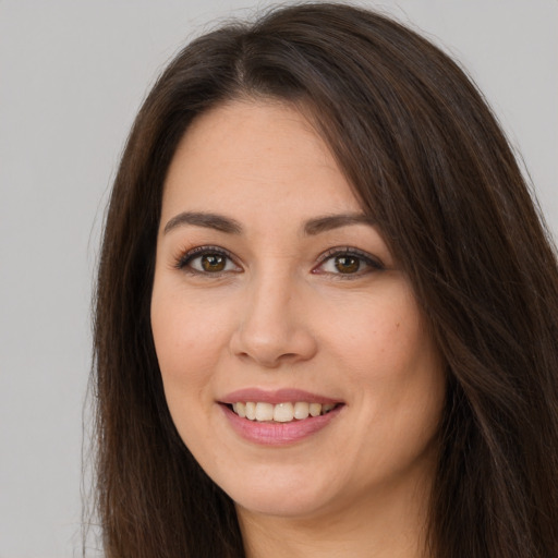 Joyful white young-adult female with long  brown hair and brown eyes