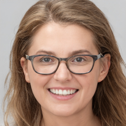 Joyful white young-adult female with long  brown hair and blue eyes