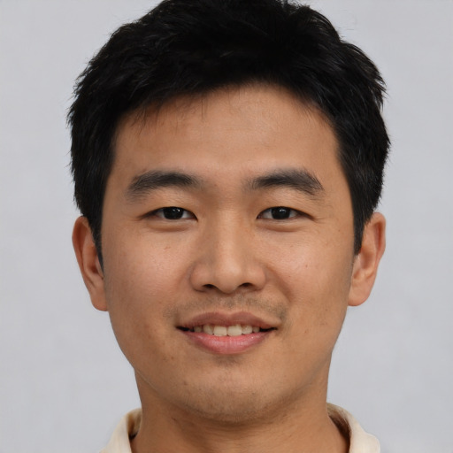 Joyful asian young-adult male with short  black hair and brown eyes