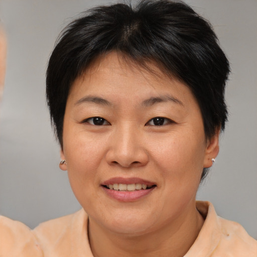 Joyful asian adult female with medium  brown hair and brown eyes