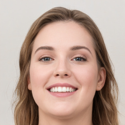 Joyful white young-adult female with long  brown hair and grey eyes