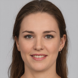 Joyful white young-adult female with long  brown hair and grey eyes