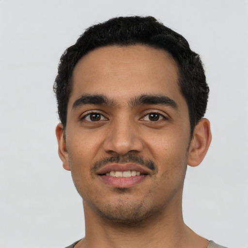 Joyful latino young-adult male with short  black hair and brown eyes