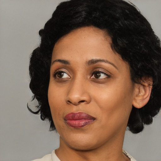 Joyful black adult female with medium  black hair and brown eyes