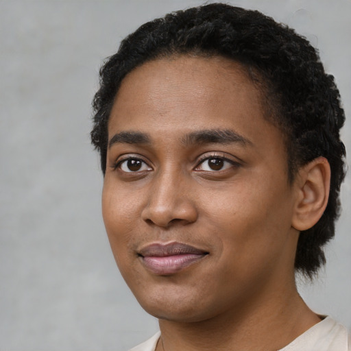 Joyful black young-adult female with short  black hair and brown eyes