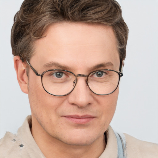 Joyful white adult male with short  brown hair and blue eyes