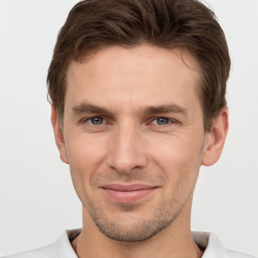 Joyful white young-adult male with short  brown hair and grey eyes