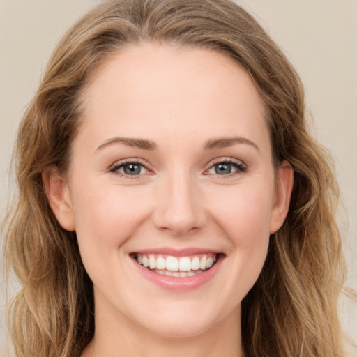 Joyful white young-adult female with long  brown hair and blue eyes