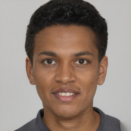 Joyful black young-adult male with short  black hair and brown eyes