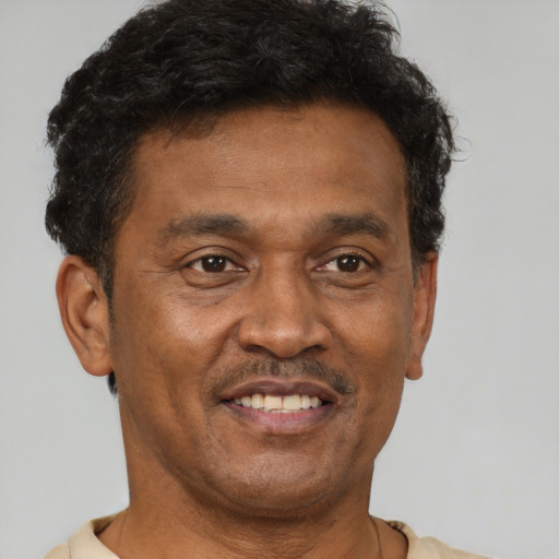 Joyful black adult male with short  brown hair and brown eyes