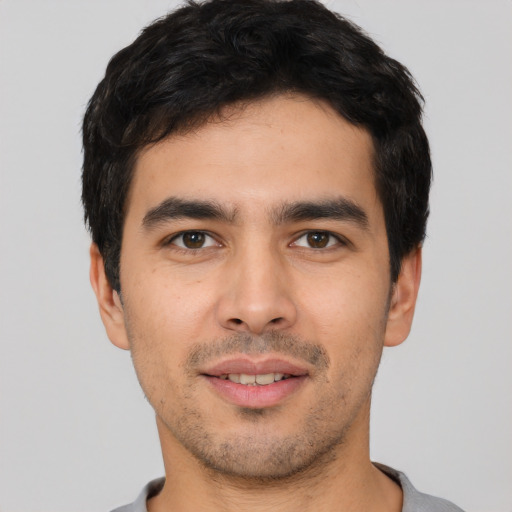 Joyful white young-adult male with short  black hair and brown eyes