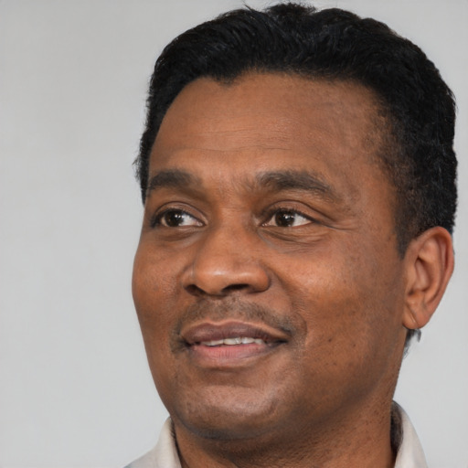 Joyful black adult male with short  black hair and brown eyes
