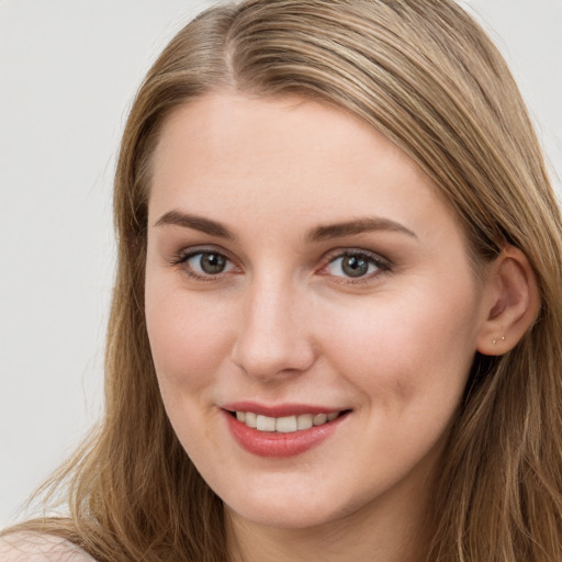 Joyful white young-adult female with long  brown hair and blue eyes