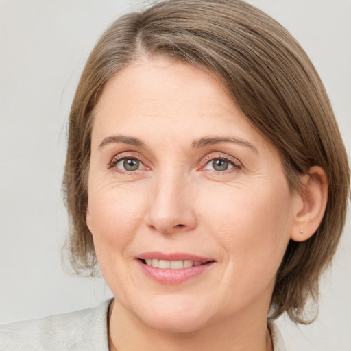 Joyful white adult female with medium  brown hair and grey eyes