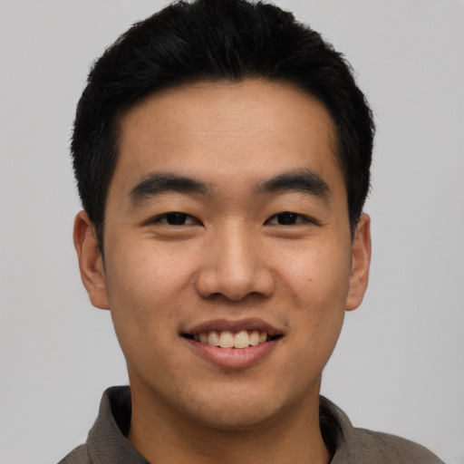 Joyful asian young-adult male with short  black hair and brown eyes