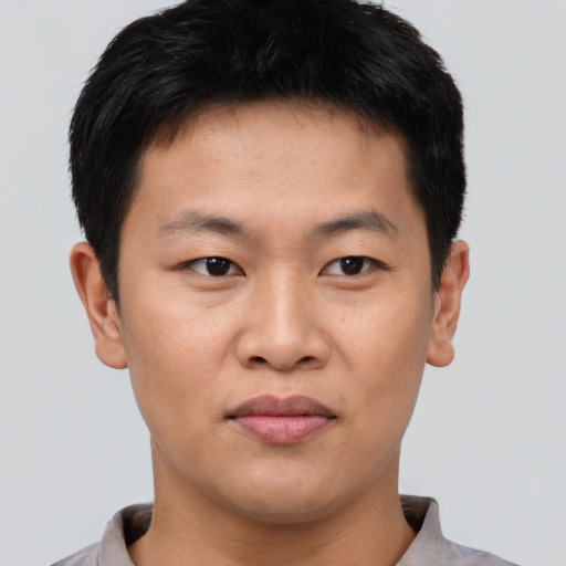 Joyful asian young-adult male with short  brown hair and brown eyes