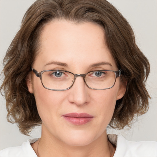 Joyful white adult female with medium  brown hair and grey eyes