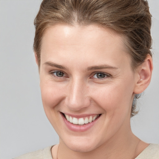 Joyful white young-adult female with short  brown hair and grey eyes