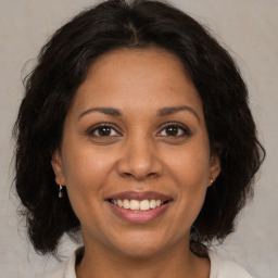 Joyful latino adult female with medium  brown hair and brown eyes