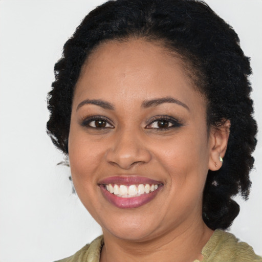 Joyful black young-adult female with long  brown hair and brown eyes