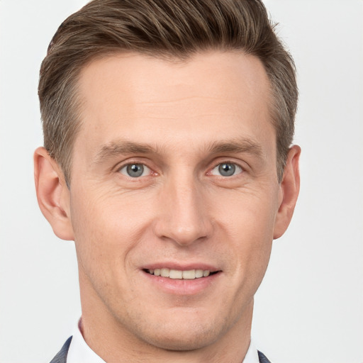 Joyful white young-adult male with short  brown hair and grey eyes