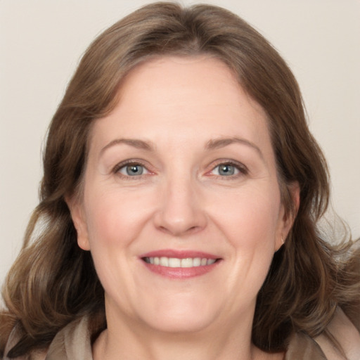 Joyful white adult female with medium  brown hair and grey eyes