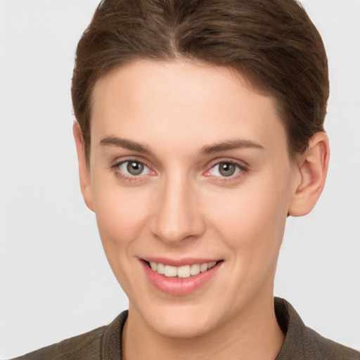 Joyful white young-adult female with short  brown hair and grey eyes