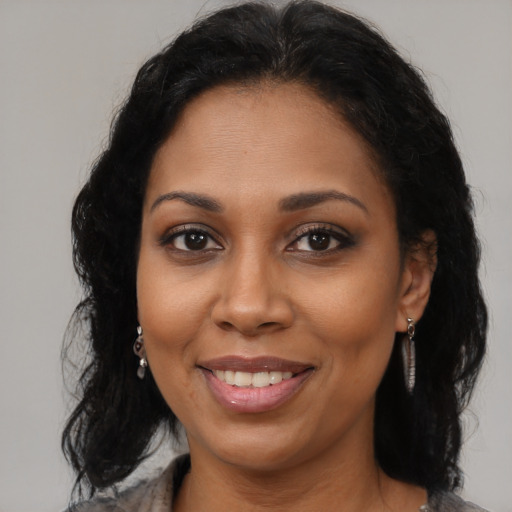 Joyful latino adult female with long  brown hair and brown eyes