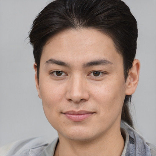 Joyful asian young-adult male with short  brown hair and brown eyes