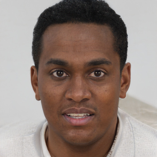 Joyful black young-adult male with short  brown hair and brown eyes