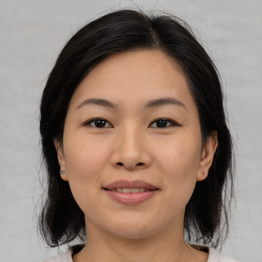Joyful asian young-adult female with medium  brown hair and brown eyes