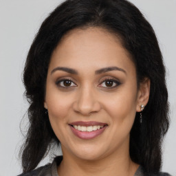 Joyful latino young-adult female with long  brown hair and brown eyes