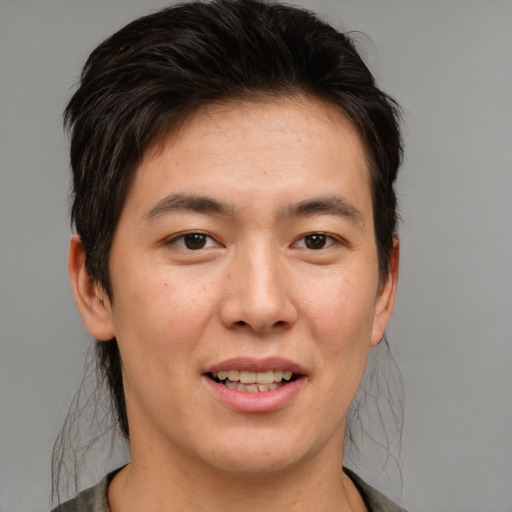 Joyful asian young-adult male with medium  brown hair and brown eyes