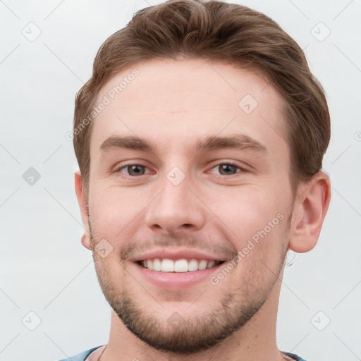 Joyful white young-adult male with short  brown hair and grey eyes