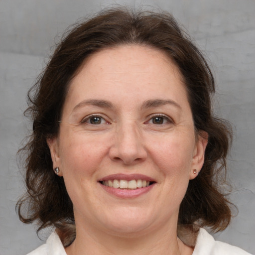 Joyful white adult female with medium  brown hair and brown eyes