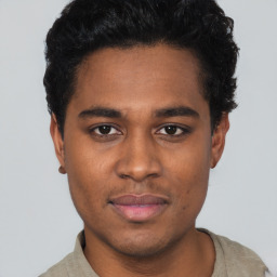 Joyful black young-adult male with short  black hair and brown eyes