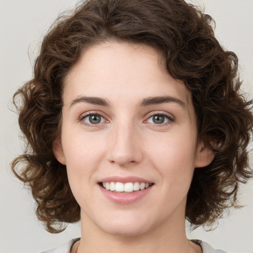 Joyful white young-adult female with medium  brown hair and green eyes