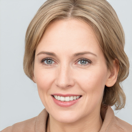 Joyful white adult female with medium  brown hair and grey eyes